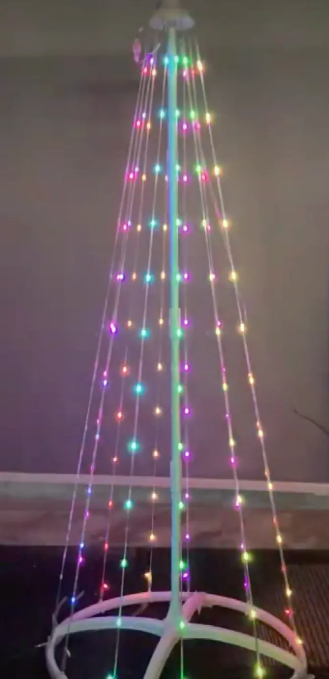 A cone-shaped Christmas light: strands of addressable LEDs hanging from a single top point down to a circular hoop on the floor, lit in mixed colours in a dim room.
