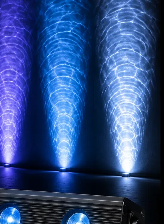 Three water ripple light beams projecting overlapping caustic patterns onto a wall in a dark room.